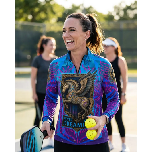 A vibrant blue and purple long-sleeved performance equestrian sun shirt with a golden winged horse and never stop dreaming text