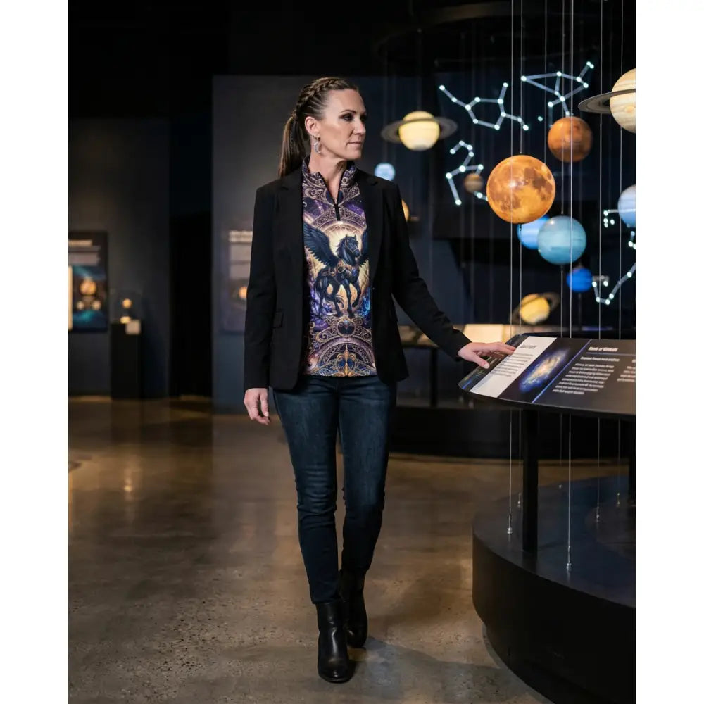 A woman wearing a black blazer over a vibrant astral ascension equestrian sun shirt with cosmic winged horse print