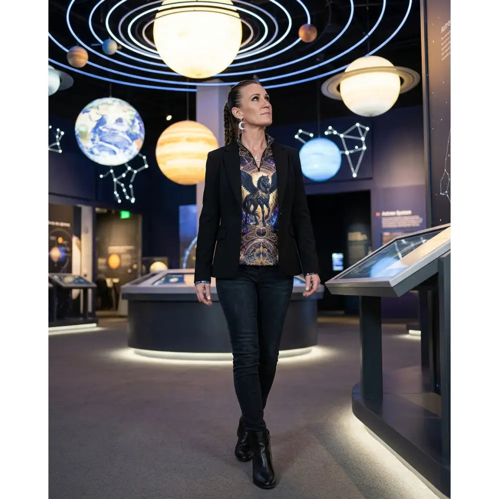 A woman wearing a black blazer over an astral ascension equestrian sun shirt with cosmic winged horse print and UPF50+ protection