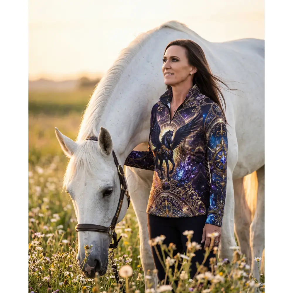 A woman wearing an astral ascension performance equestrian sun shirt with a cosmic winged horse print and purple nebula design