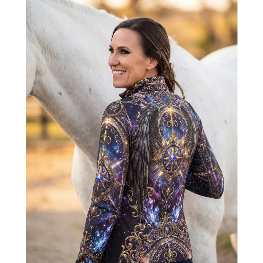 A woman wears the astral ascension performance equestrian sun shirt upf50 plus with cosmic galaxy design and gold accents