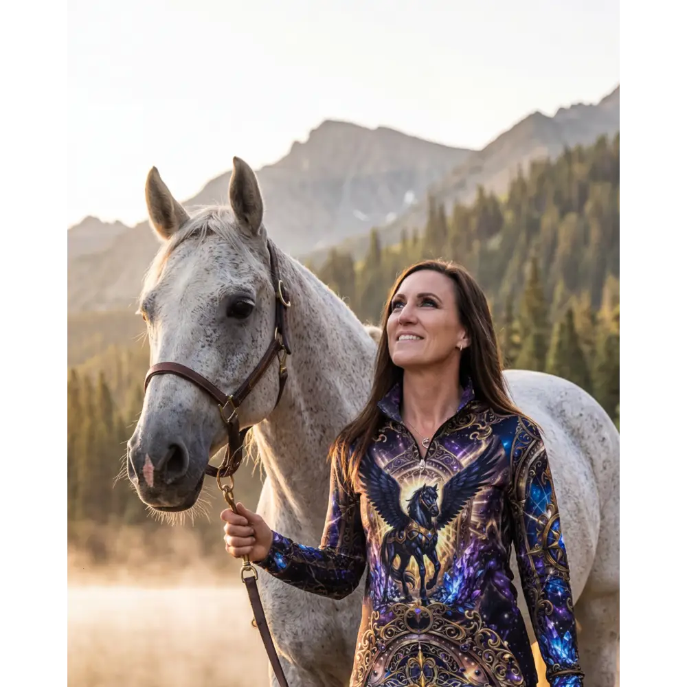 A woman wears an astral ascension performance equestrian sun shirt with cosmic winged horse design upf50+