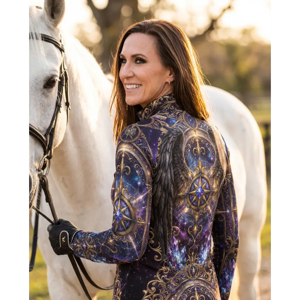 A woman wears a long-sleeved high-neck astral ascension performance equestrian sun shirt with cosmic gold and purple design