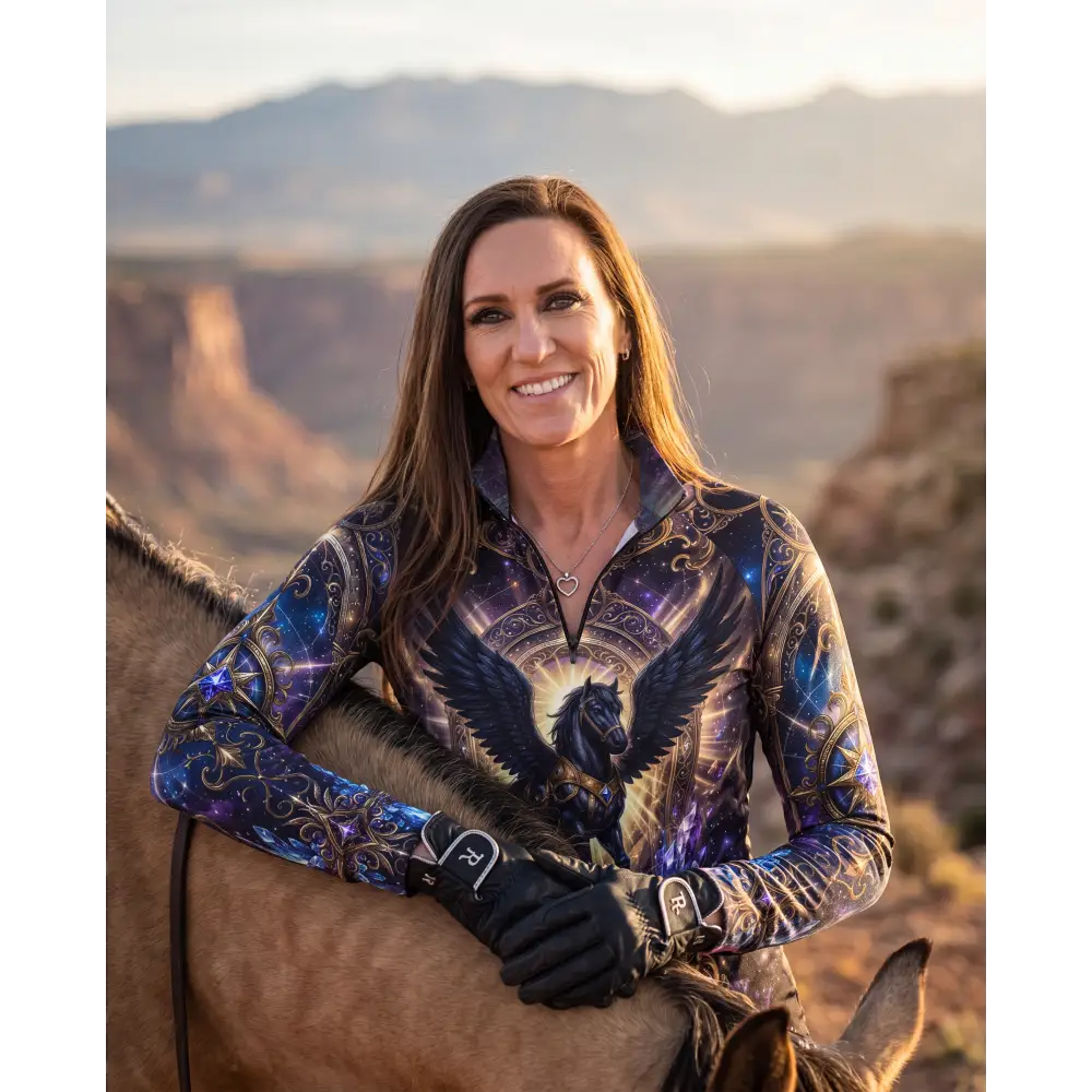 A woman wearing an astral ascension performance equestrian sun shirt with a cosmic black winged horse design