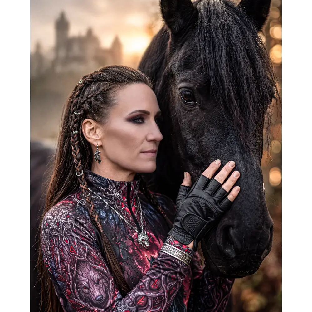 A woman wearing a red and black wolf-patterned blood moon hunt performance equestrian sun shirt upf50+ gently touches a black horse