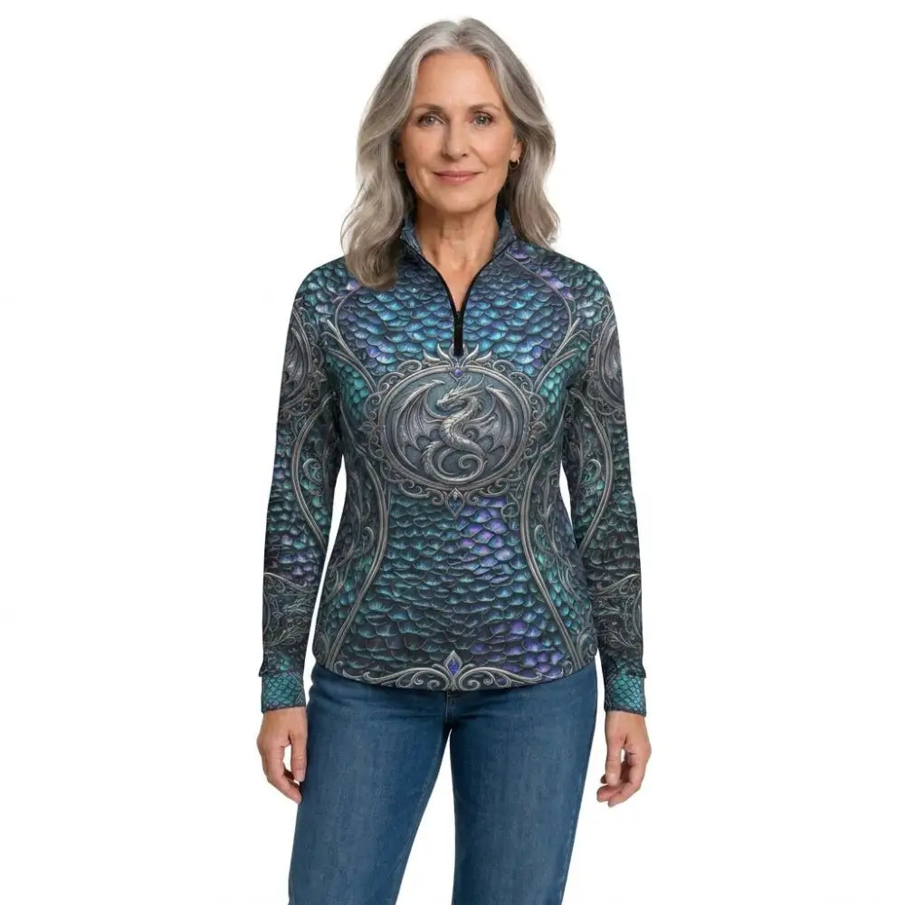 A woman wearing a teal and purple dragon-scale patterned caelestia draconis performance equestrian sun shirt upf50+