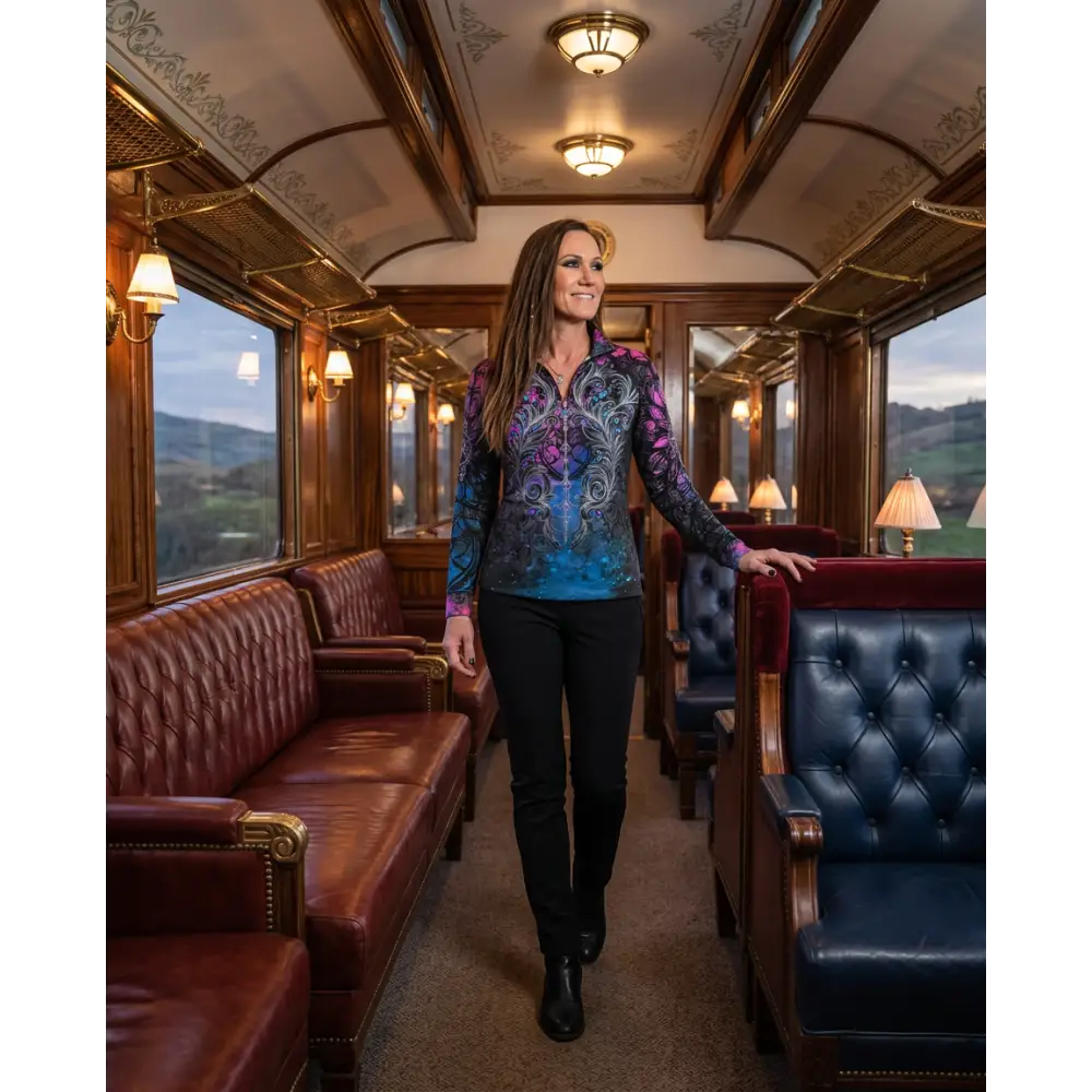 A woman wearing a midnight radiance performance equestrian sun shirt in purple and blue floral quarter zip design