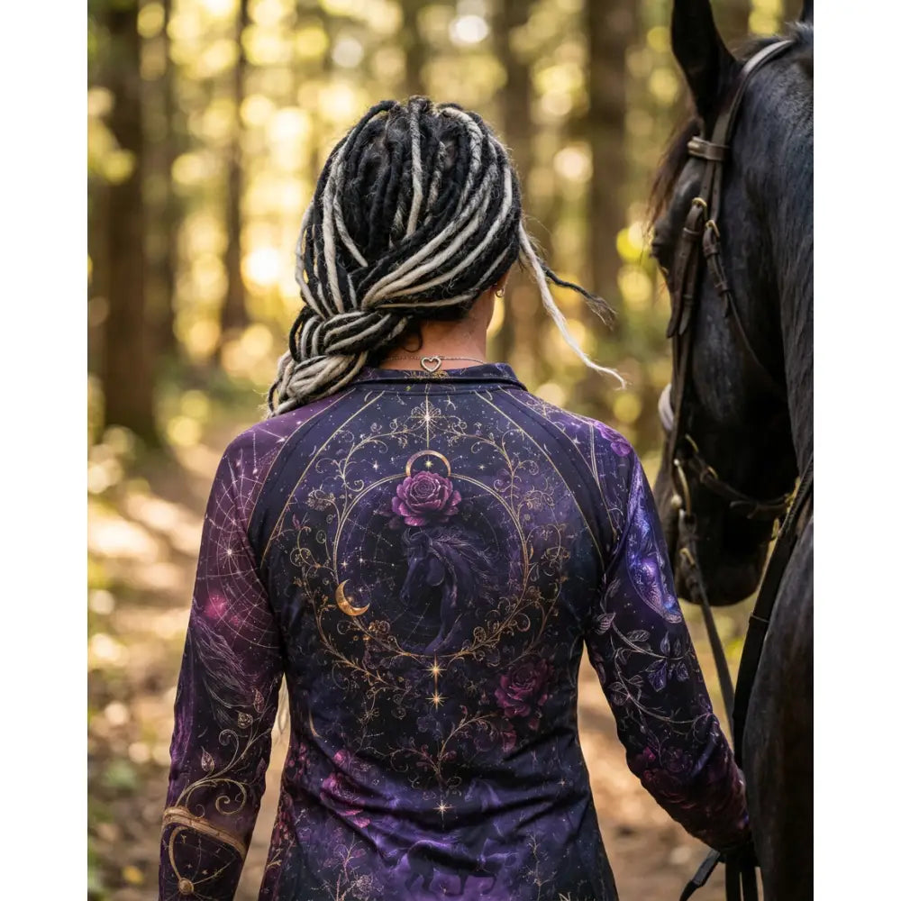 A woman wearing a dark purple moonthorn nocturne long-sleeved UPF50+ equestrian sun shirt by karen reinertson with celestial horse and rose print