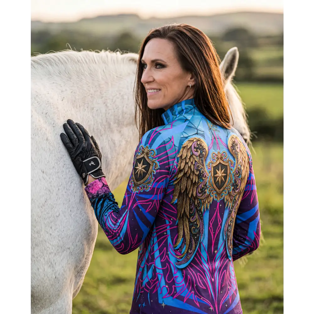 A vibrant electric blue and magenta long-sleeved performance equestrian sun shirt with angel wing and shield designs