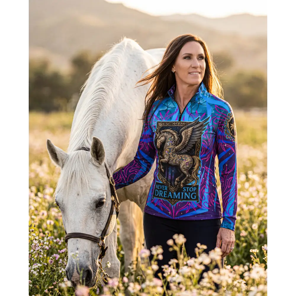 Never stop dreaming performance equestrian sun shirt in vibrant blue and purple with golden winged horse emblem and upf50+ protection