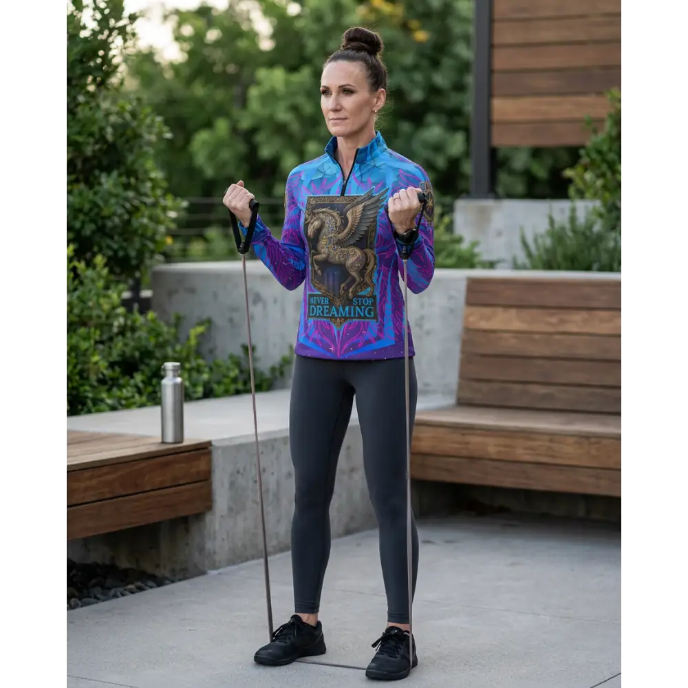 A vibrant blue and purple long-sleeved performance equestrian sun shirt with golden winged horse and never stop dreaming text