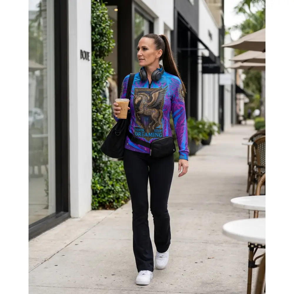 Vibrant blue and purple long-sleeved performance equestrian sun shirt with golden griffin and never stop dreaming text