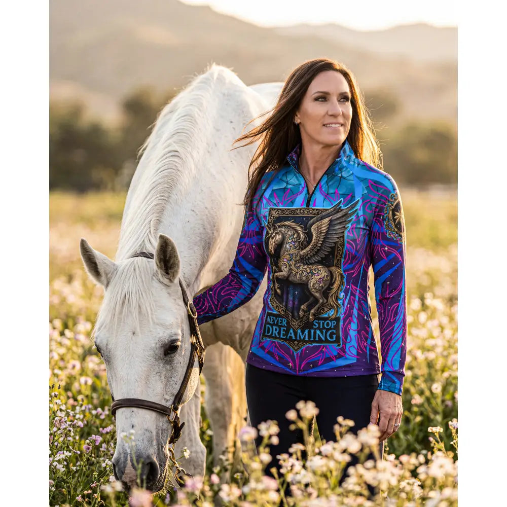 Vibrant blue and purple long-sleeved performance equestrian sun shirt with golden winged horse and never stop dreaming text