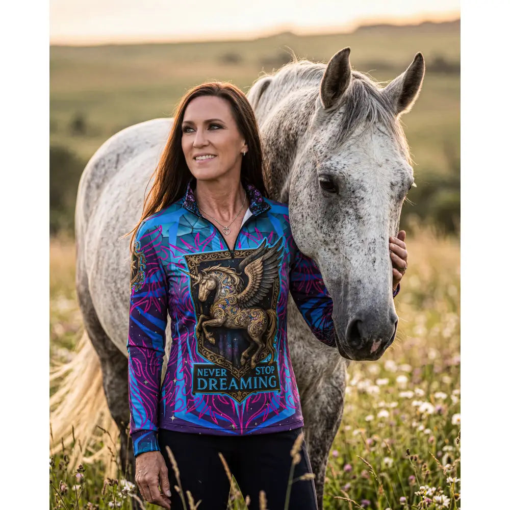 Vibrant blue and purple long-sleeved performance equestrian sun shirt with golden winged horse and never stop dreaming text