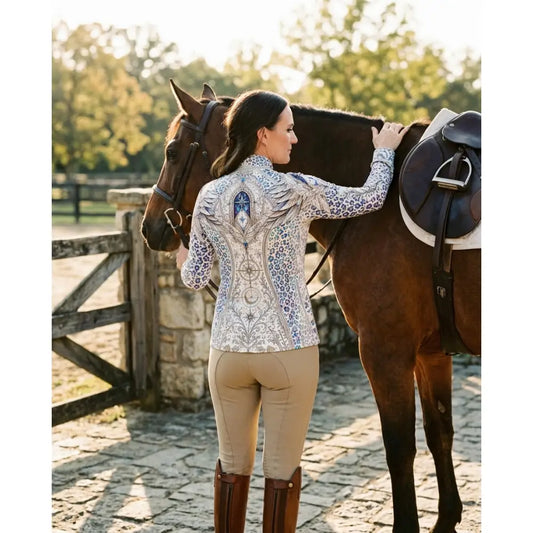 A woman wears the back of a pantera arcana equestrian sun shirt with blue gray arcane wing and scale print by karen reinertson
