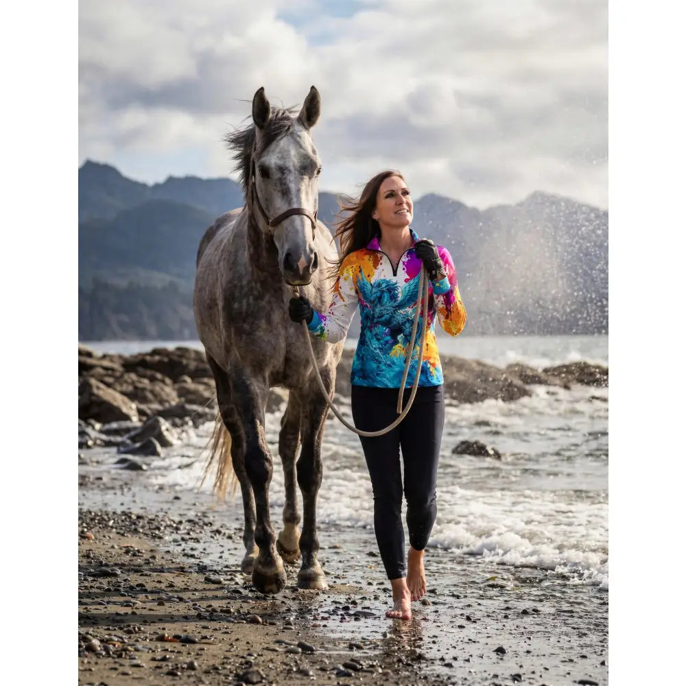 Woman wearing riptide radiance UPF50+ equestrian sun shirt with vibrant tie-dye blue yellow orange wearable art print