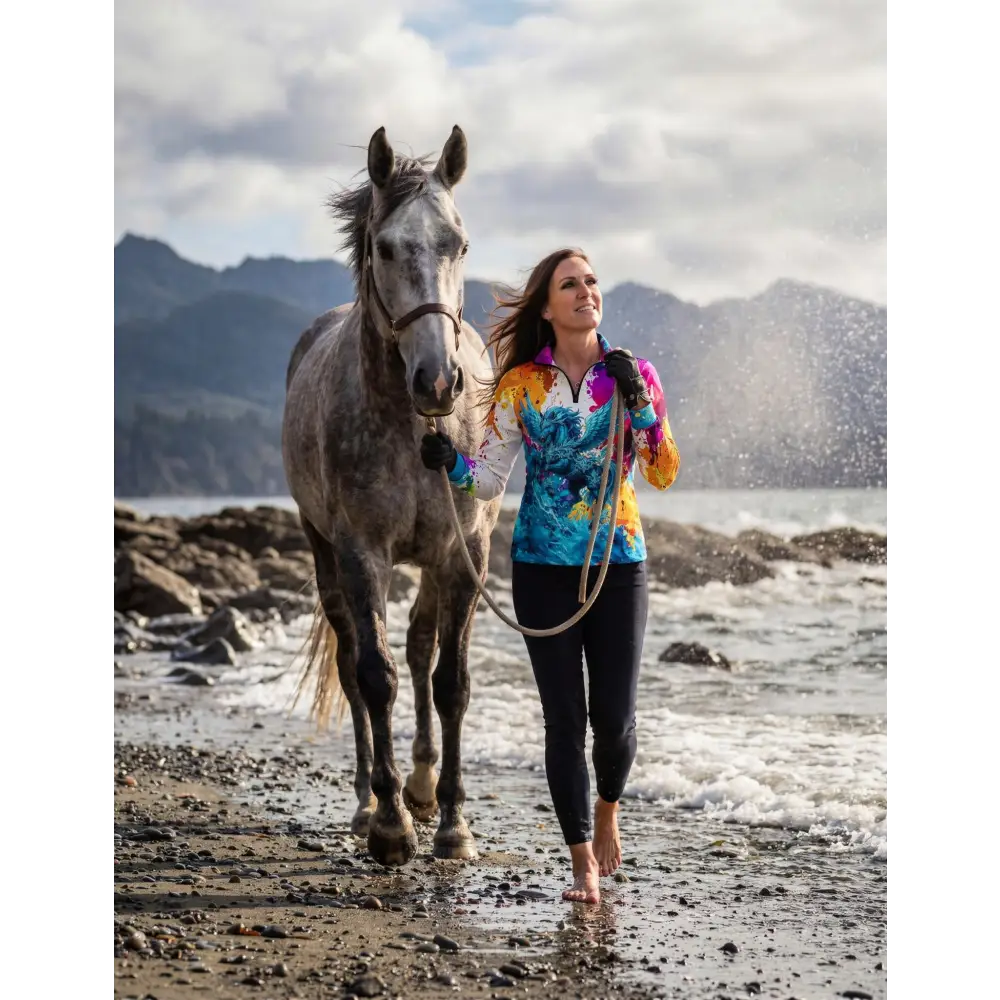 Woman wearing riptide radiance performance equestrian sun shirt upf50 plus in vibrant blue yellow and orange tie dye
