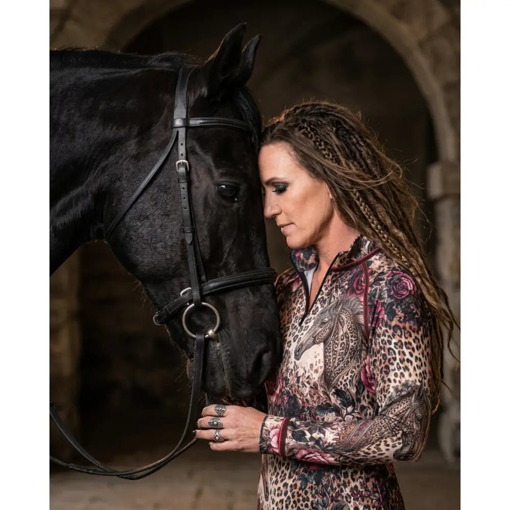 A woman wearing a rosae equiferus equestrian sun shirt by Karen Reinertson with leopard rose horse print and pink roses