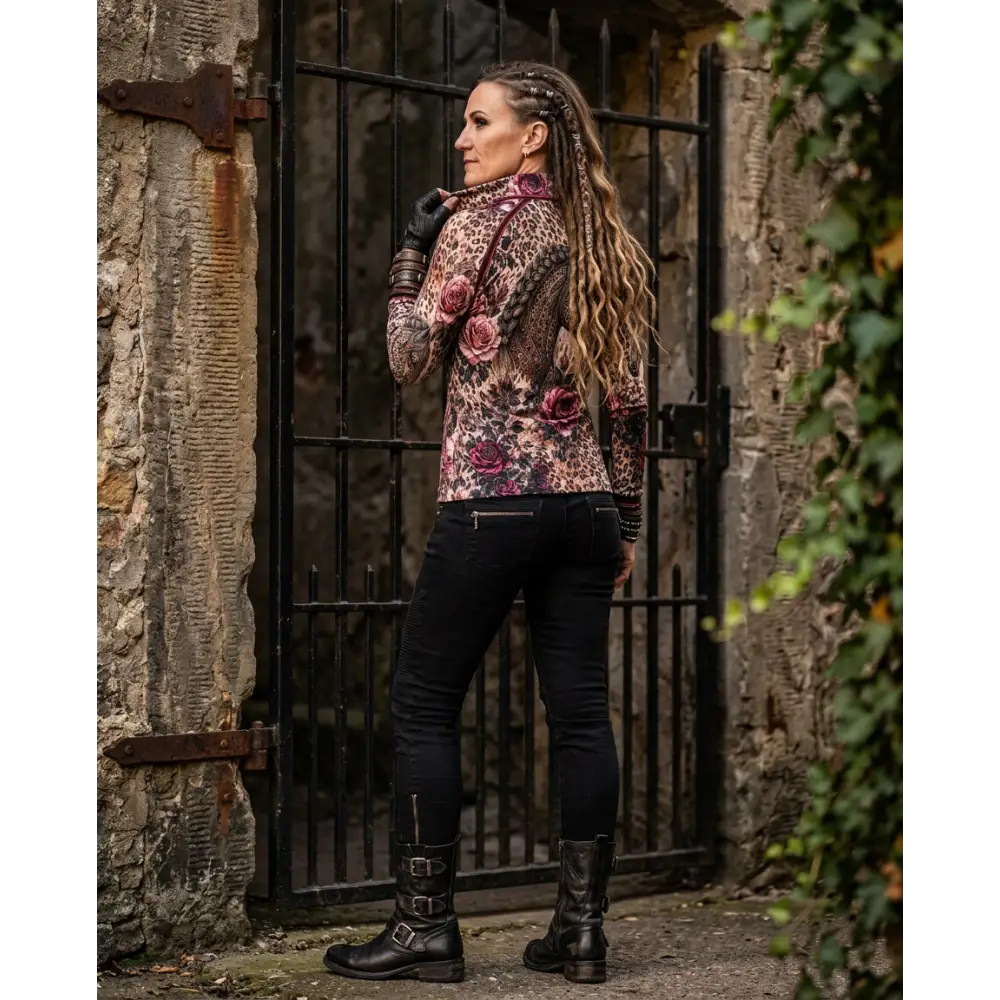 A woman wears a leopard print rosae equiferus equestrian sun shirt with embroidered pink roses and black jeans