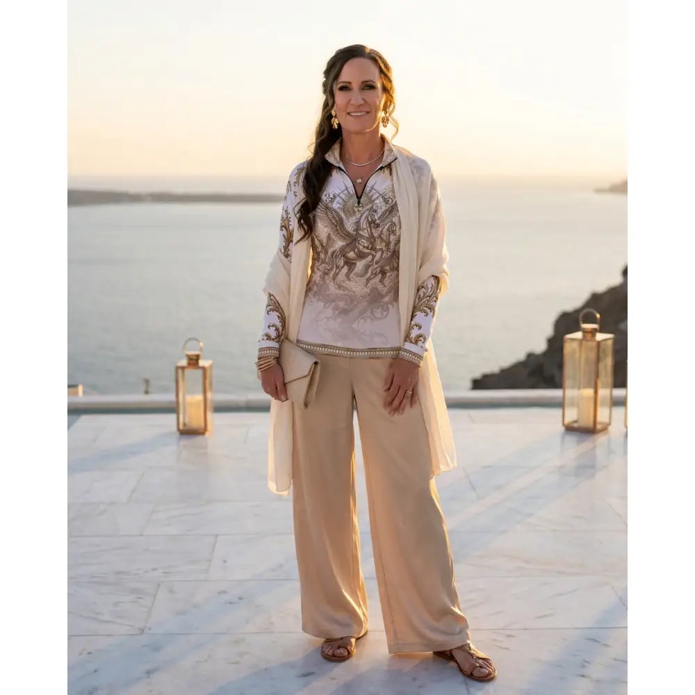 A woman wears a beige solis aeternum equestrian sun shirt with ornate golden horse embroidery from ripley signature collection wearable art