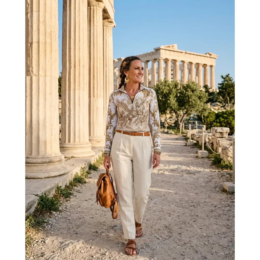 A woman carrying a tan leather backpack with structured design and stitching at an ancient greek site wearing solis aeternum wearable art sun shirt