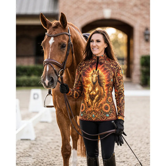 A woman wears the sunfire sovereign performance equestrian sun shirt with a golden horse print and turquoise accents