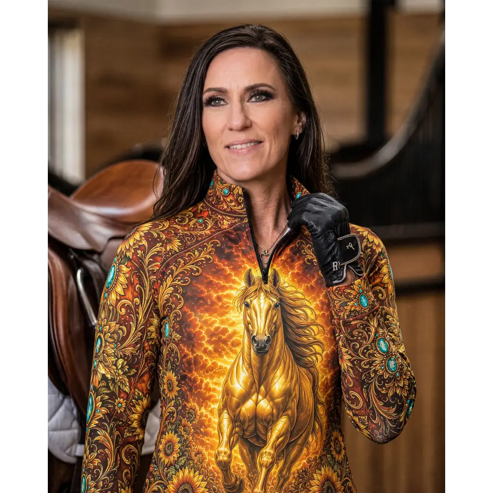 A woman wearing a sunfire sovereign performance equestrian sun shirt with golden horse and sunflower design in orange brown