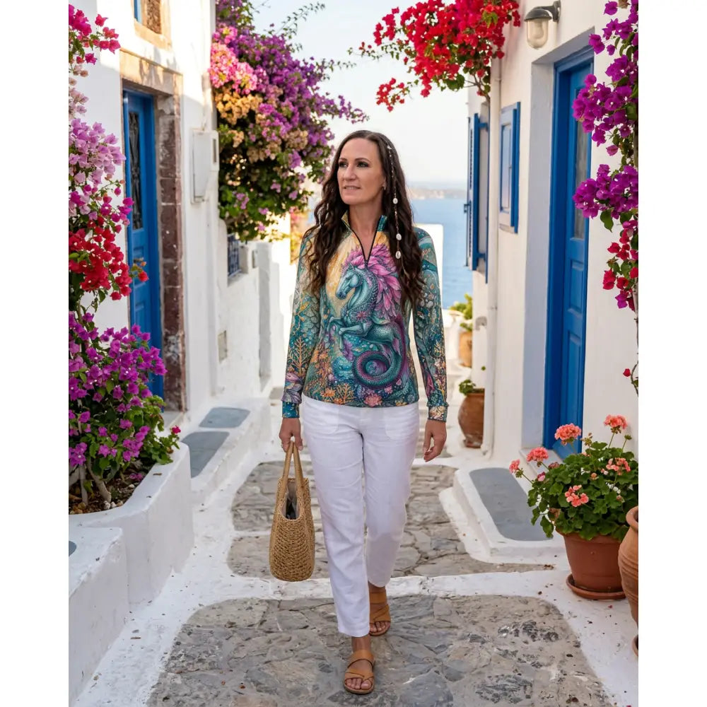 A woman wears a vibrant multicolored tidewoven reefborn equestrian sun shirt featuring reef ecosystems wearable art