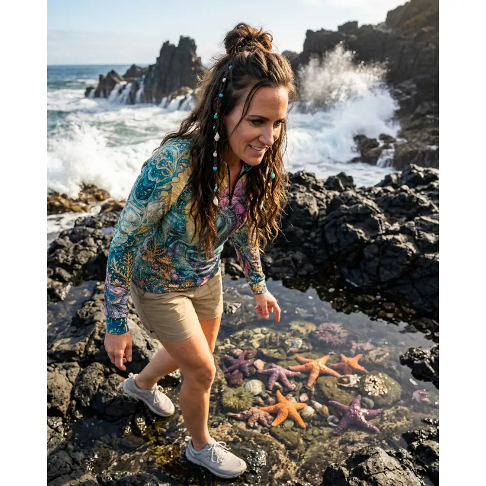 Woman wearing tidewoven reefborn ocean reef print upf50+ equestrian sun shirt in teal and purple wearable art performance apparel