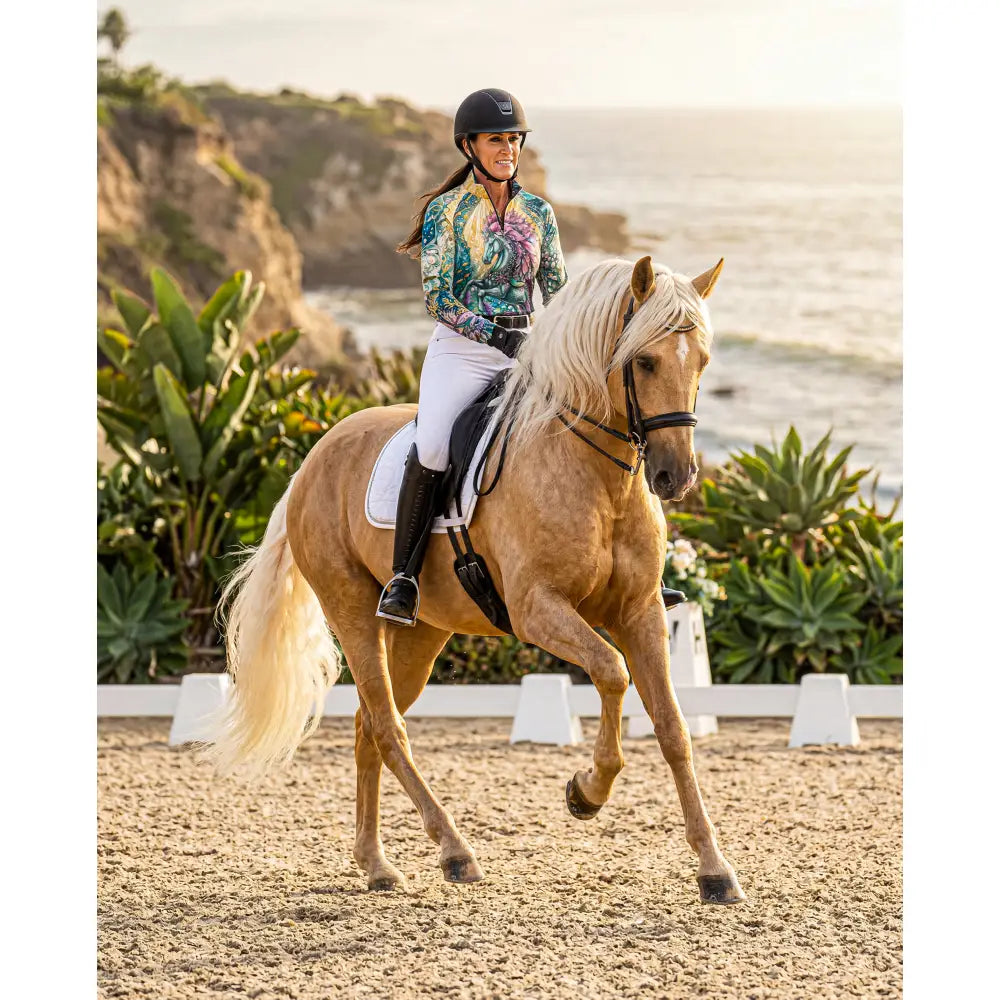 A light brown horse with flowing blonde mane in tidewoven reefborn ocean reef print upf50+ equestrian sun shirt wearable art