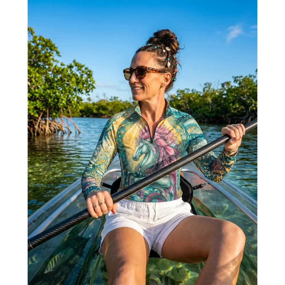 A woman wears tidewoven reefborn UPF50+ equestrian sun shirt with vibrant reef ecosystems unicorn floral design