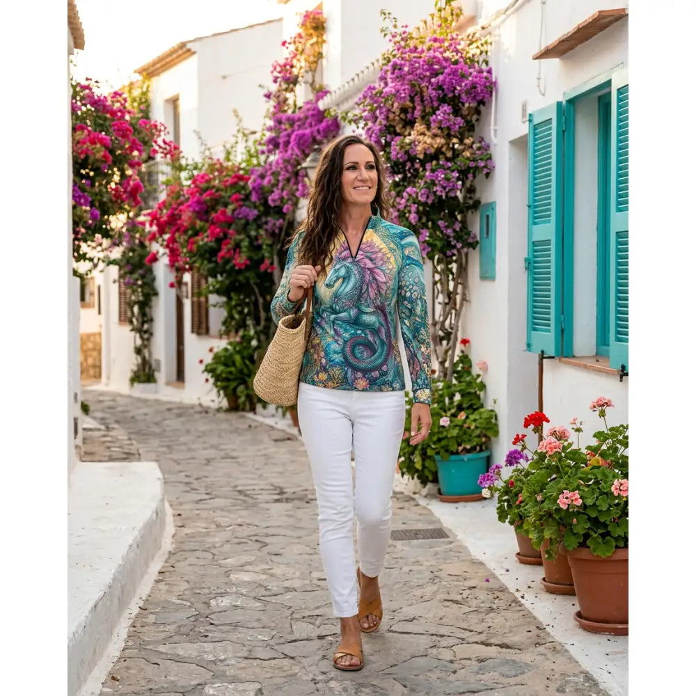 A woman wearing a vibrant tidewoven reefborn equestrian sun shirt with teal and purple reef ecosystems performance apparel design