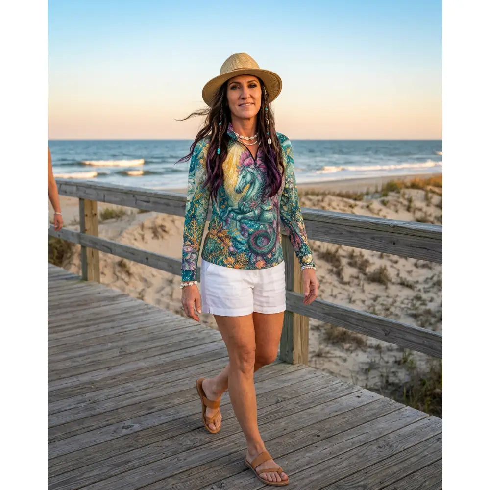 Woman wearing tidewoven reefborn equestrian sun shirt in green and purple with unicorn and floral reef ecosystems print
