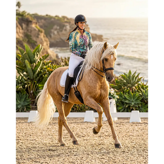 A light brown horse mid-gait wearing a tidewoven reefborn performance equestrian sun shirt upf50 plus outdoors
