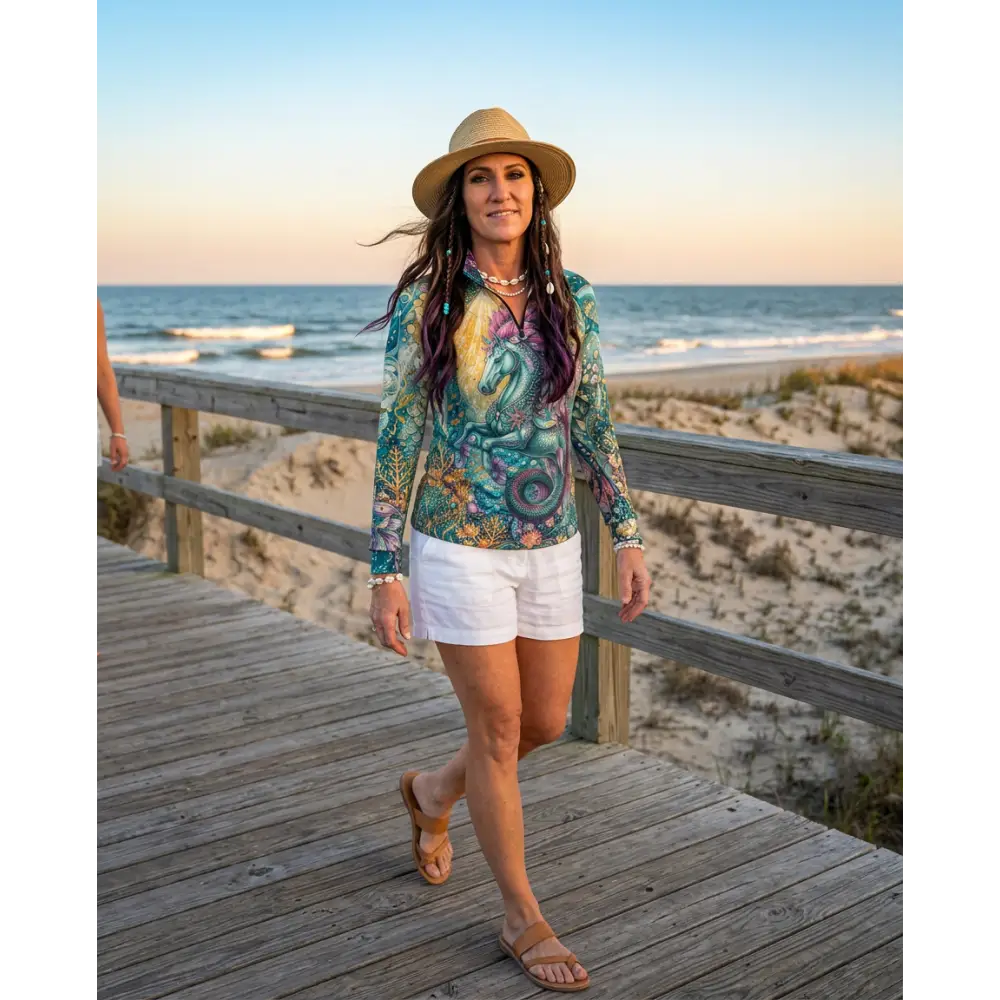 Woman wearing a vibrant green and purple Tidewoven Reefborn performance equestrian sun shirt with unicorn and floral patterns