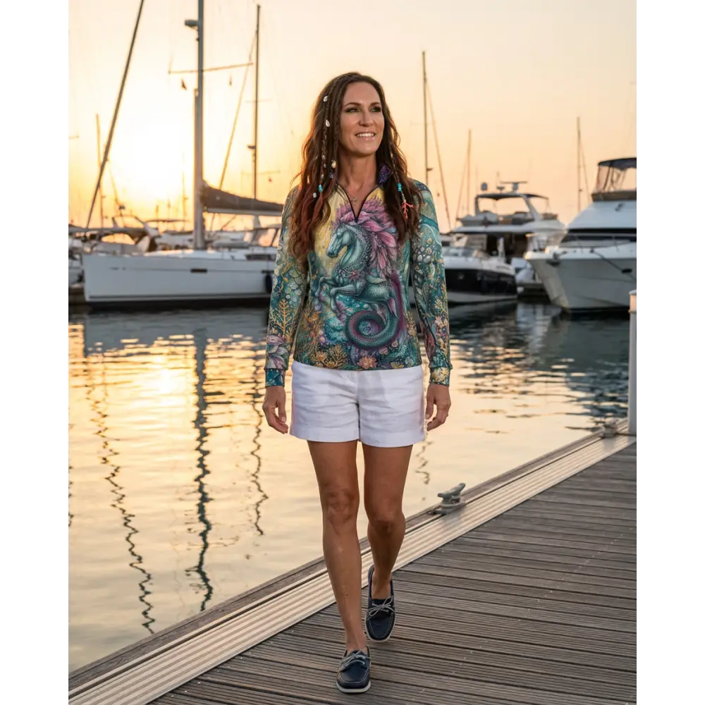 A woman wearing a tidewoven reefborn performance equestrian sun shirt upf50 plus with teal and purple dragon design