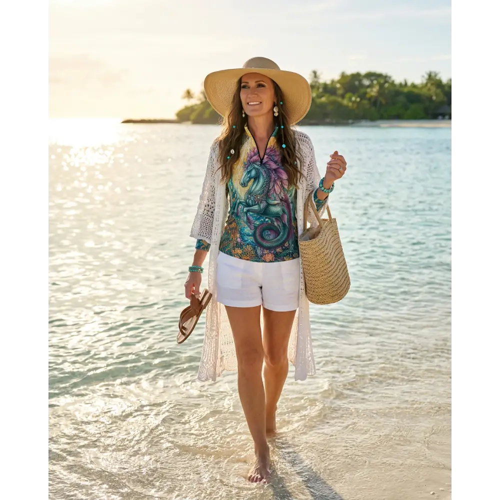 Woman wearing tidewoven reefborn performance equestrian sun shirt upf50 plus in colorful dragon print under crochet cardigan
