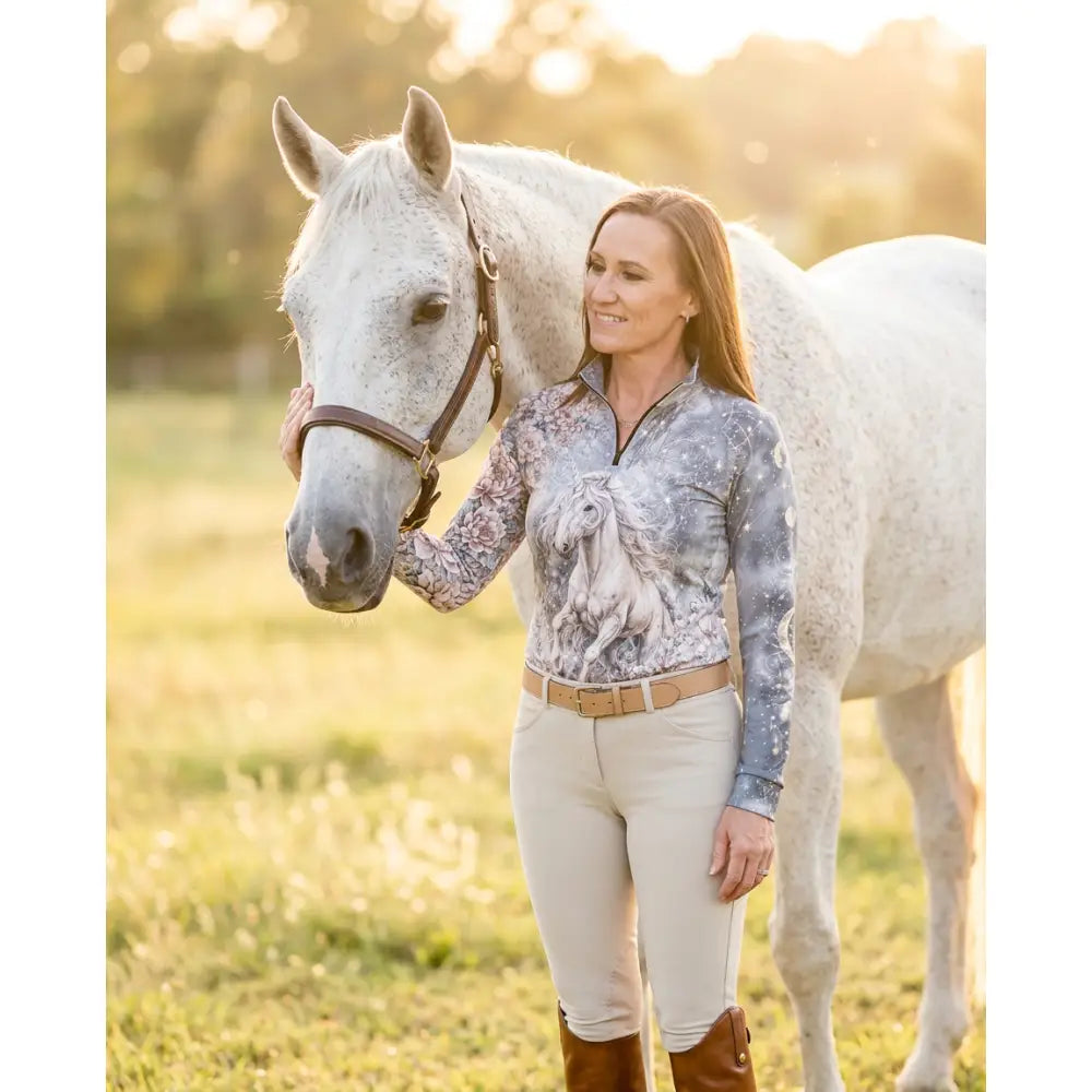 A woman wearing a gray and white unicornis caelestis equestrian sun shirt with horse print and subtle starry texture by karen reinertson