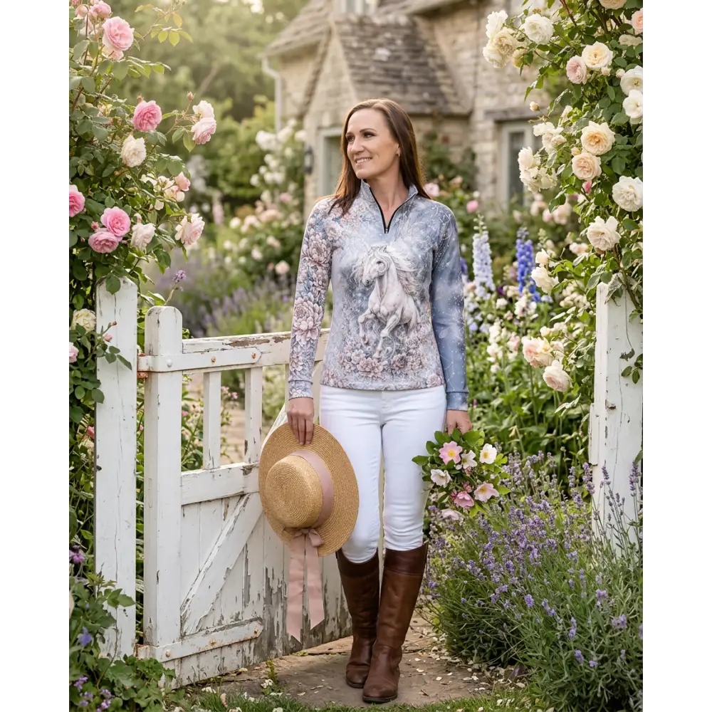 A woman wearing a long-sleeved unicornis caelestis performance equestrian sun shirt with a white horse print and UPF50+ protection